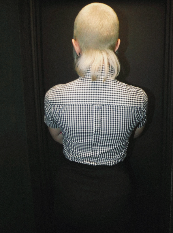 Person wearing a black and white checkered shirt against a dark background