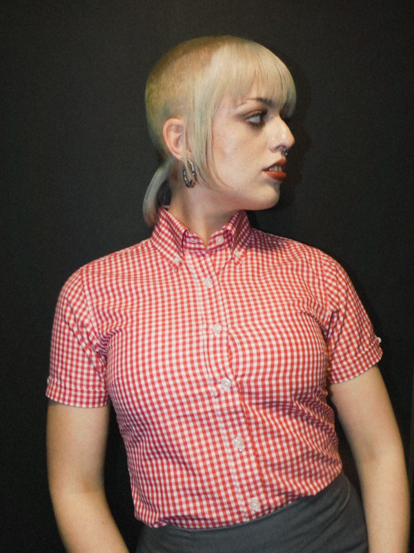 Person wearing a red and white checkered shirt against a black background