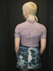 Person wearing a checkered shirt and denim skirt against a black background